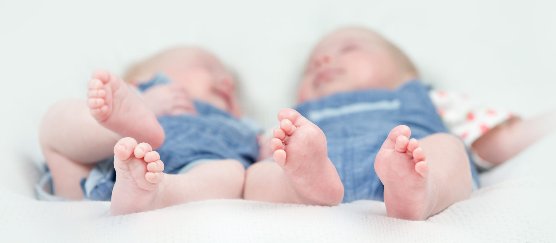 Neugeborene Zwillinge liegen auf einem Bett
